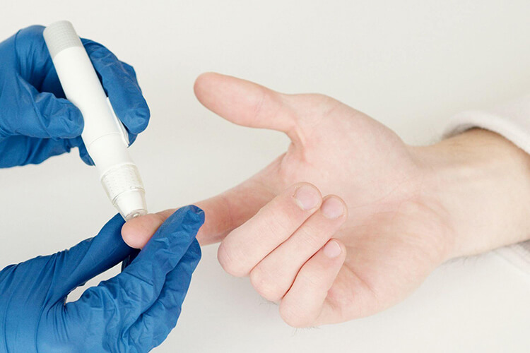 A person using a finger prick for blood test. Consult primary care for diabetes with Side Health.